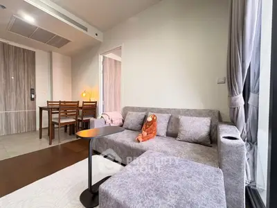 Modern living room with cozy gray sofa and dining area in stylish apartment