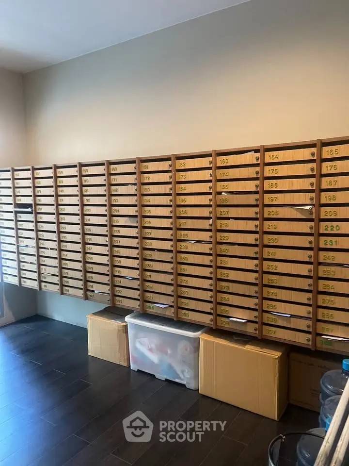 Spacious storage room with organized wooden mailboxes and dark wood flooring