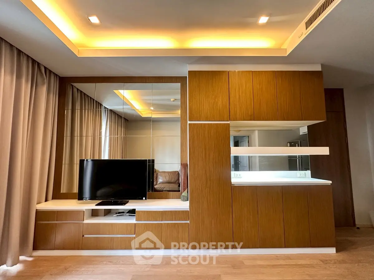 Modern living room with stylish wooden cabinetry and ambient lighting