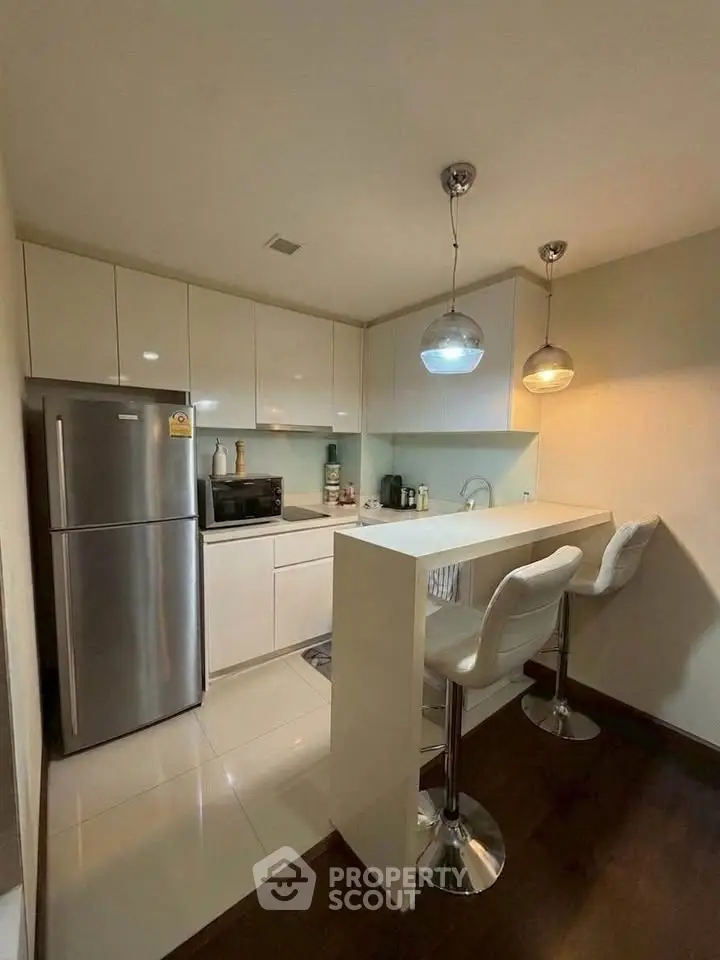 Modern kitchen with sleek white cabinets and breakfast bar seating