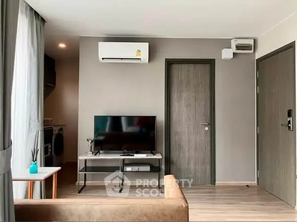 Modern living room with air conditioning and TV, featuring sleek furniture and neutral tones.
