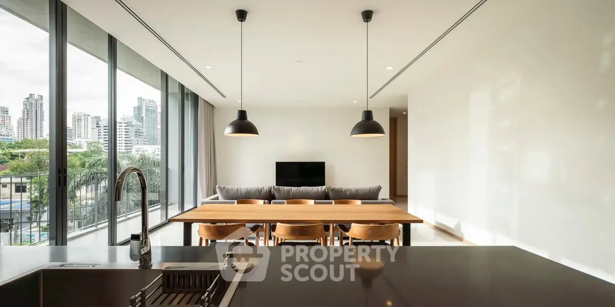 Modern open-plan living and dining area with city view and sleek design.