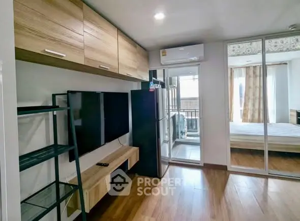 Modern apartment interior with living room and bedroom, featuring sleek wooden flooring and contemporary furnishings.