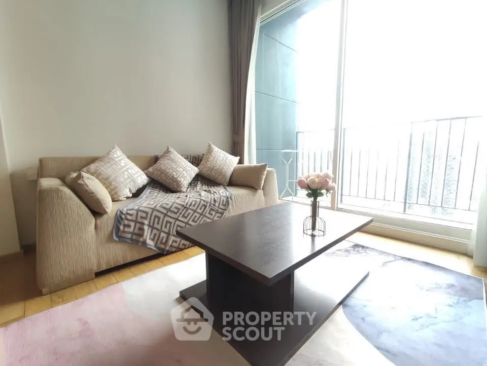 Bright living room with cozy sofa and modern coffee table near large window and balcony.