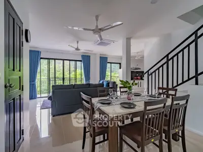 Spacious open-plan living and dining area with modern furnishings and large windows.
