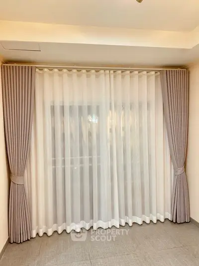 Elegant room with floor-to-ceiling curtains and soft lighting, perfect for cozy living.