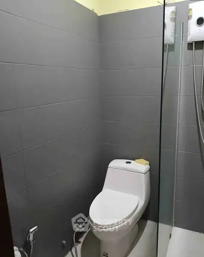Compact bathroom with modern fixtures and gray tile walls.