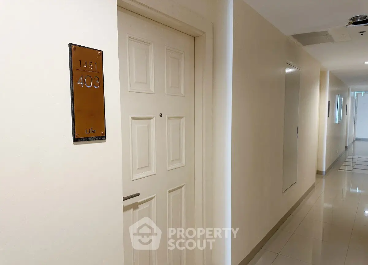Modern apartment hallway with sleek door and polished floors