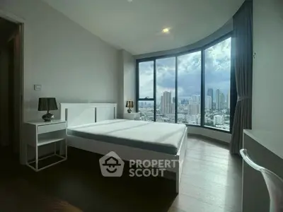 Luxurious bedroom with stunning city view and modern furnishings in high-rise apartment.
