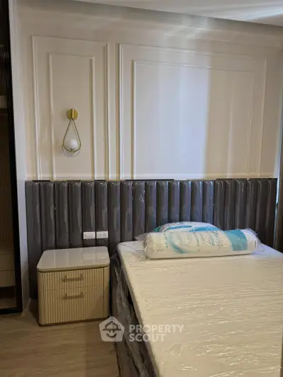 Elegant bedroom with modern decor and stylish wall paneling, featuring a cozy bed and chic bedside table.