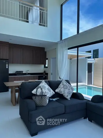 Luxurious living room with pool view and modern kitchen in open layout