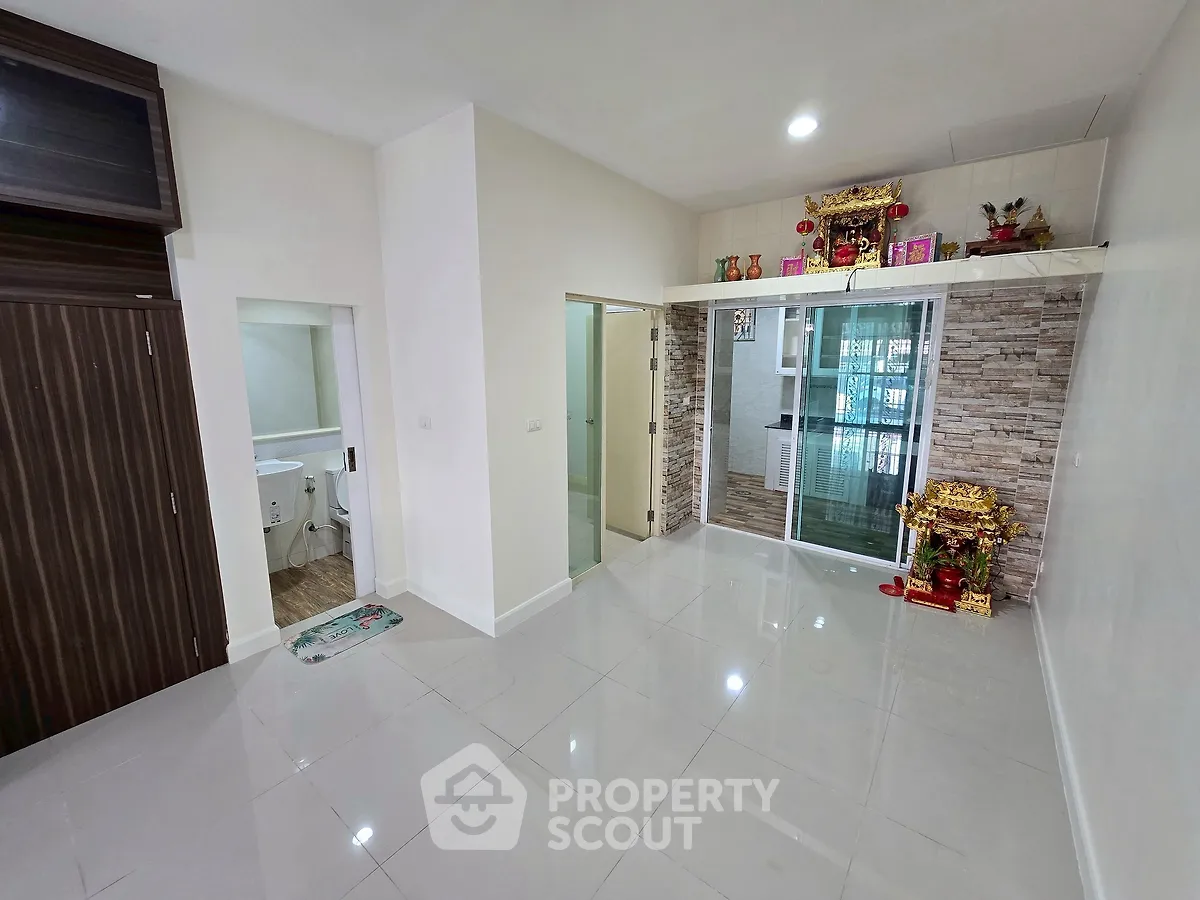Spacious living room with modern tile flooring and decorative wall accents in a contemporary apartment.