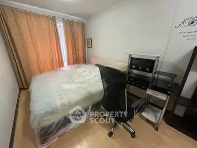 Cozy bedroom with natural light, featuring a comfortable bed and modern office chair, ideal for work-from-home setup.