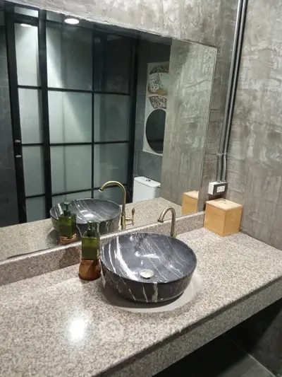 Modern industrial bathroom with stylish marble sink and granite countertop