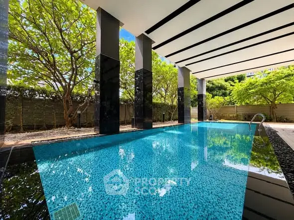 Luxurious modern pool area with sleek design and lush greenery, perfect for relaxation and leisure.
