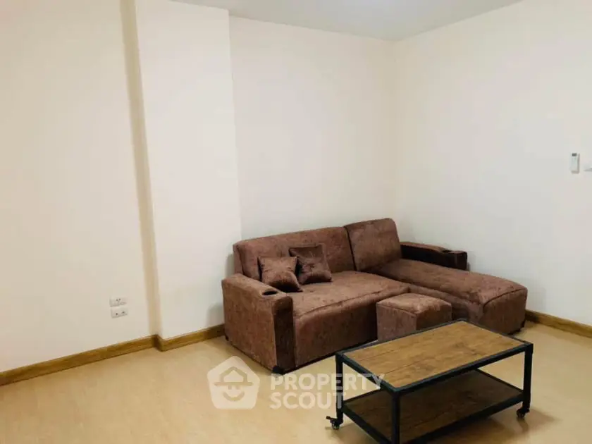 Cozy living room with brown sectional sofa and wooden coffee table, perfect for relaxation.