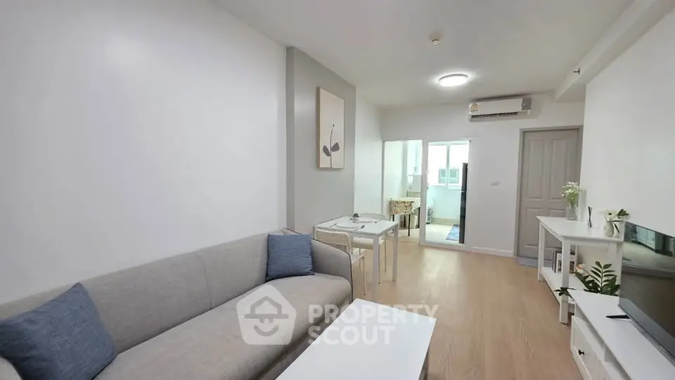 Modern living room with cozy gray sofa and minimalist decor in bright apartment.