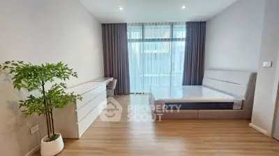 Spacious modern bedroom with large window and minimalist decor