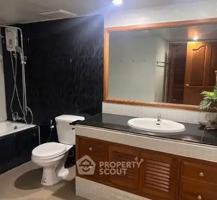Spacious bathroom with modern fixtures and elegant dark accent wall