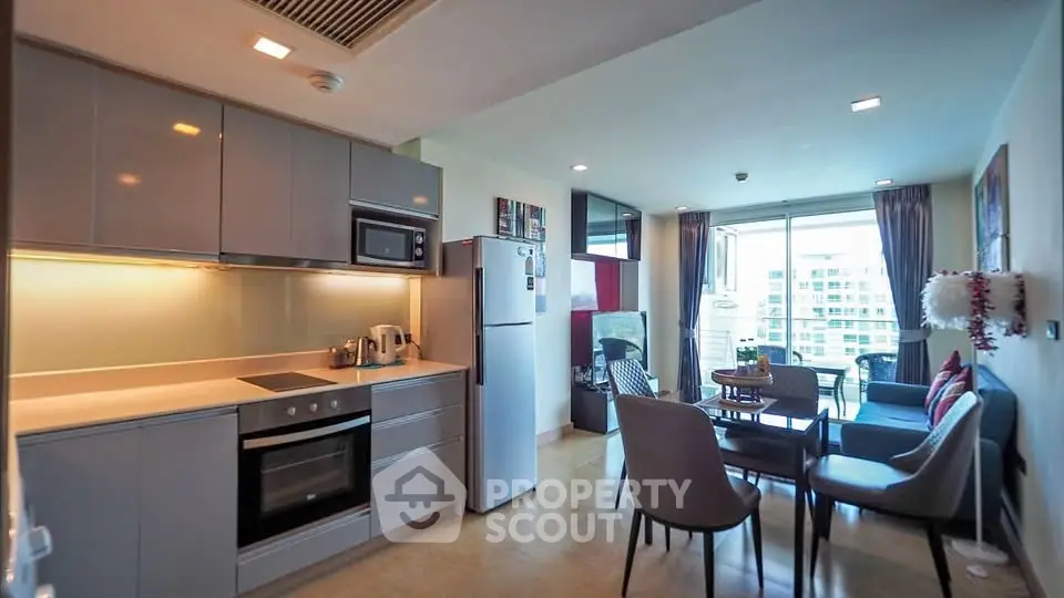 Modern open-layout kitchen and living room with sleek appliances and bright natural light.