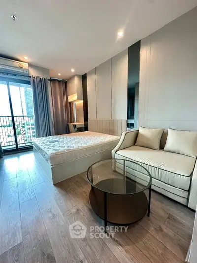 Modern bedroom with large windows and city view, featuring a cozy bed and stylish furniture.