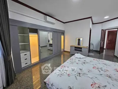 Spacious bedroom with built-in wardrobe and floral bedding