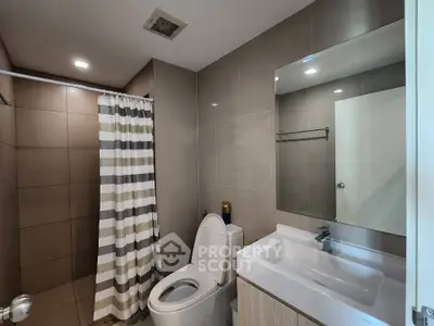 Modern bathroom with sleek fixtures and striped shower curtain