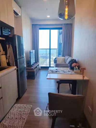 Modern apartment with open layout, featuring a cozy living area and stunning city view from the balcony.