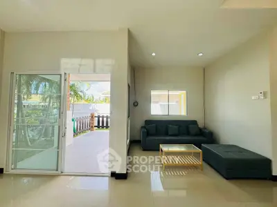 Spacious living room with modern furniture and sliding glass doors leading to a patio.
