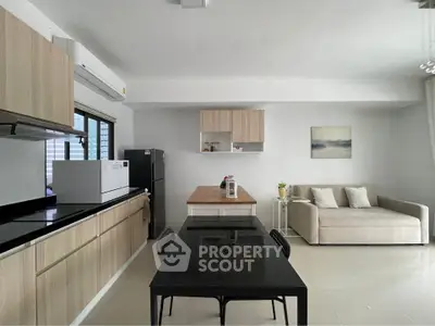 Modern open-layout kitchen and living area with sleek furniture and natural light.