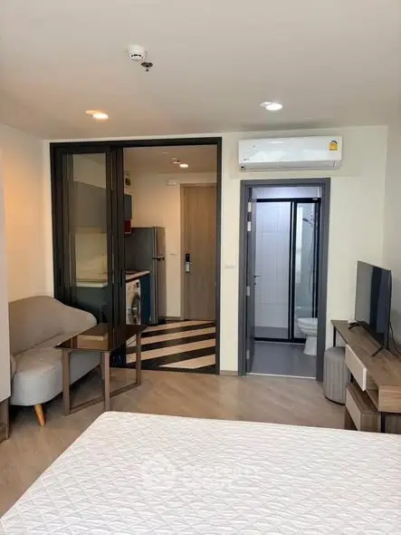 Modern studio apartment with open layout, featuring a cozy living area, compact kitchen, and stylish bathroom.