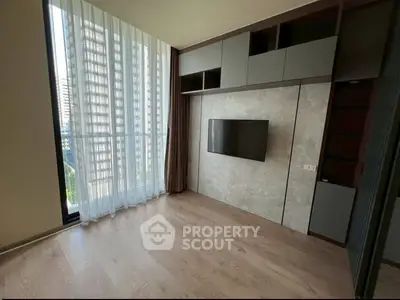 Modern living room with floor-to-ceiling windows and built-in TV unit in a high-rise apartment.