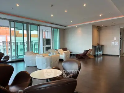 Spacious modern living room with stylish furniture and large windows offering city views.