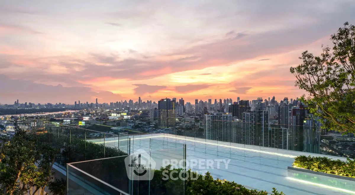 Stunning rooftop view with infinity pool overlooking city skyline at sunset.