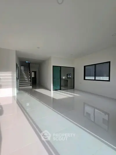 Spacious modern living room with glossy white tiles and large windows