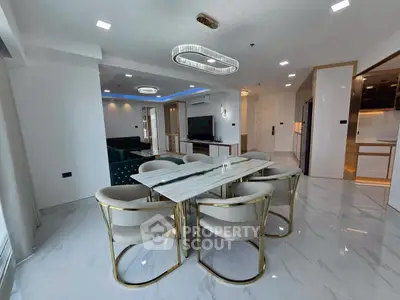 Luxurious modern dining area with marble table and elegant lighting in open-plan living space.