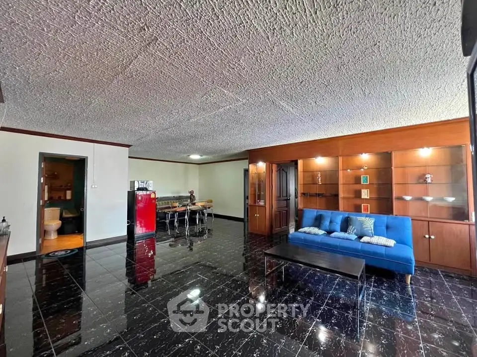 Spacious living room with modern decor and glossy black tile flooring