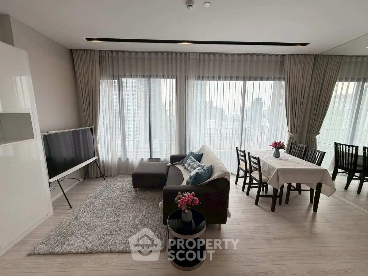 Spacious modern living room with city view, elegant decor, and dining area