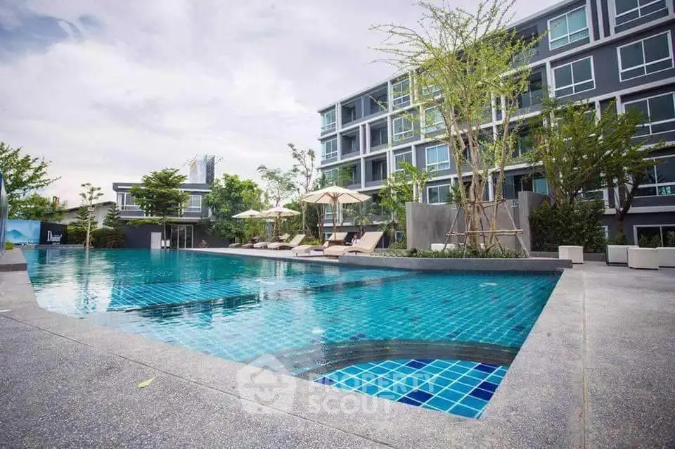 Luxurious modern apartment complex with stunning pool and lush greenery