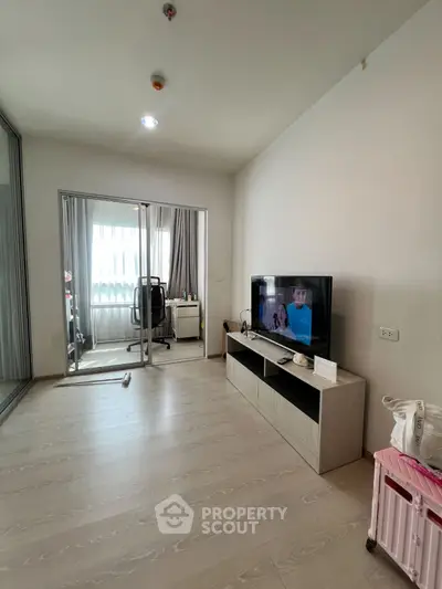Spacious living room with modern TV setup and glass partition to study area.