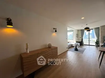 Spacious living room with modern decor and city view, featuring stylish lighting and wooden flooring.