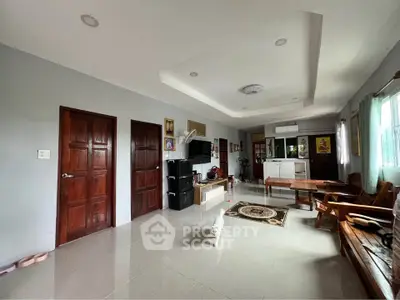 Spacious living room with modern decor and ample natural light, featuring wooden furniture and sleek flooring.