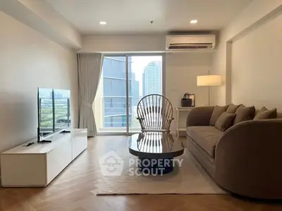 Modern living room with city view, stylish furniture, and natural light.