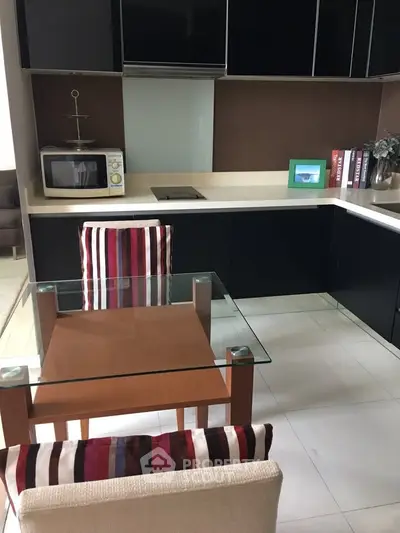 Modern kitchen with sleek black cabinets and glass dining table