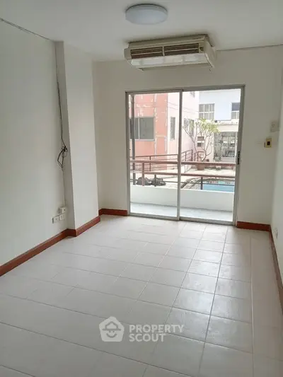 Bright empty room with air conditioning and balcony access in modern apartment.