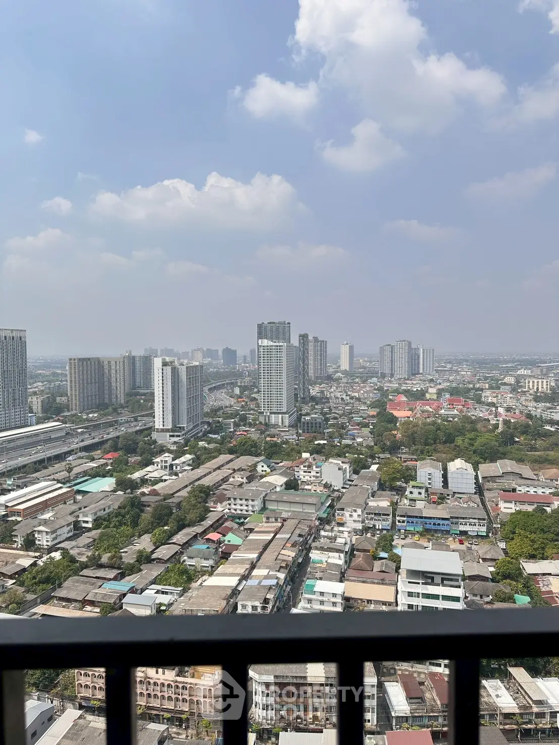 Stunning cityscape view from high-rise balcony showcasing urban skyline and expansive horizon.