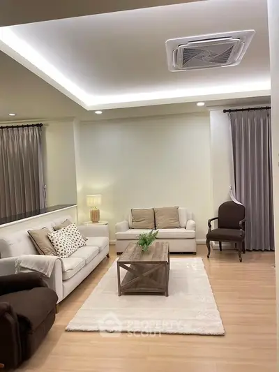 Elegant living room with cozy sofas, stylish decor, and warm lighting for a welcoming ambiance.