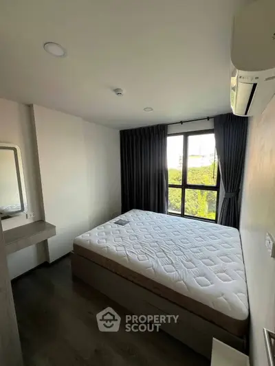 Modern bedroom with large window and air conditioning, featuring a comfortable bed and sleek design.