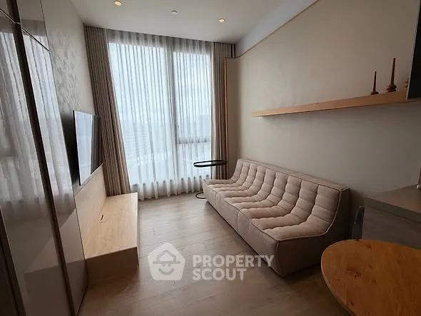 Modern living room with sleek sofa and large window offering natural light