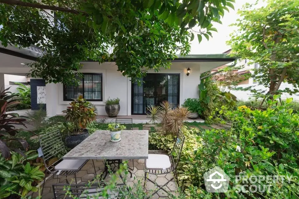 Charming garden patio with lush greenery and elegant outdoor seating